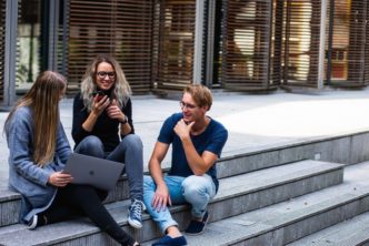 Three Persons Sitting On The Stairs Talking With Each Other 1438072