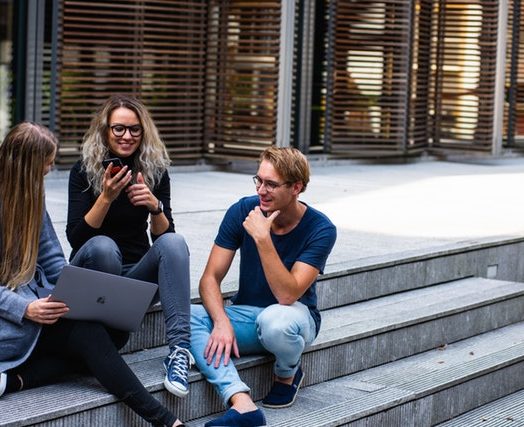 Three Persons Sitting On The Stairs Talking With Each Other 1438072