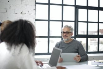 Positive Adult Man With Tablet Working With Colleagues In 3932236