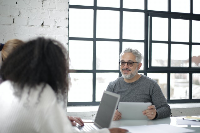 Positive Adult Man With Tablet Working With Colleagues In 3932236